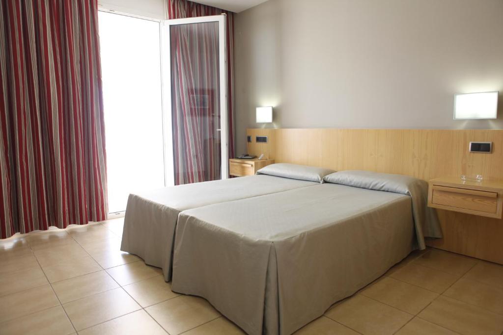 a bedroom with a large bed and a window at Hotel Adiafa in Barbate