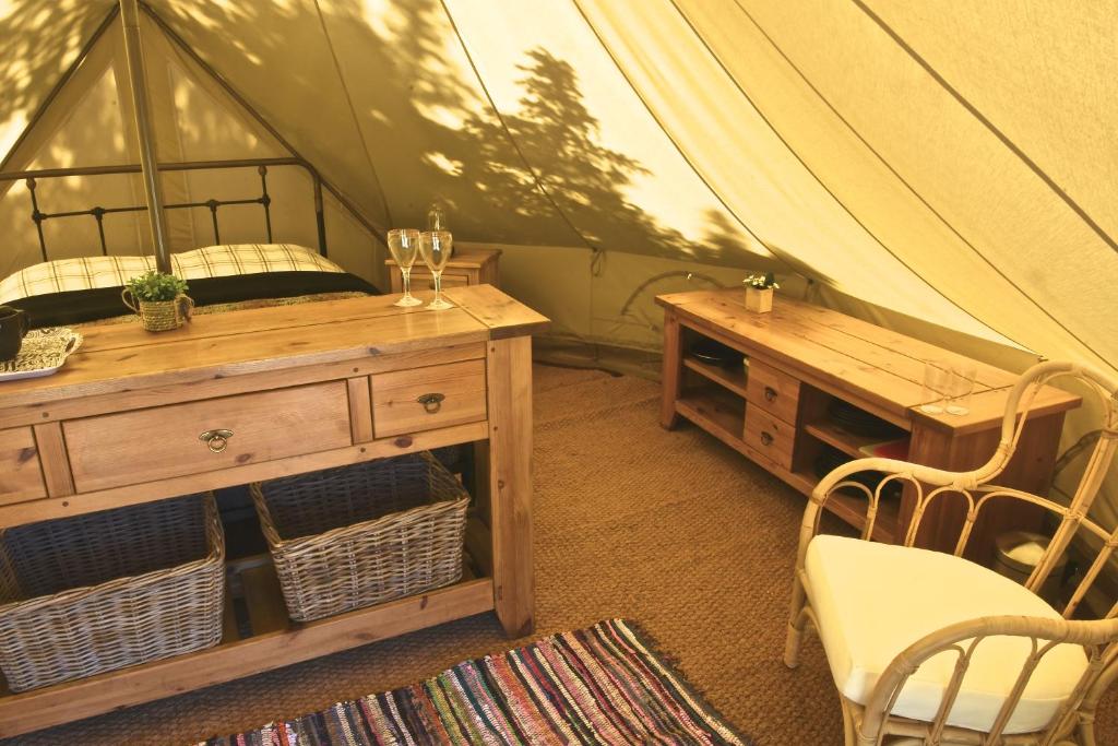 a room with a bed and a table in a tent at Glamping at Camping La Source in Saint-Pierre-dʼArgençon