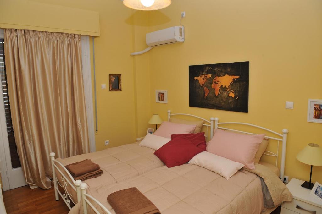 1 dormitorio con cama blanca y almohadas rojas en Cozy ACROPOLIS, en Atenas