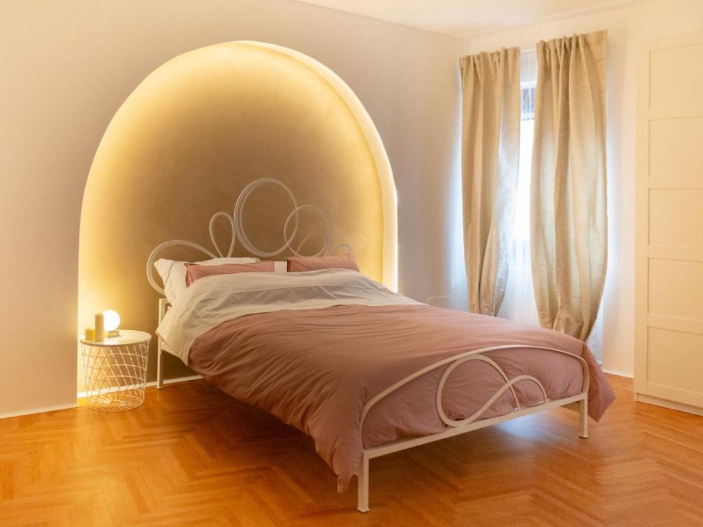 ein Bett mit einem großen Kopfteil in einem Schlafzimmer in der Unterkunft Casa Ristori in Cividale del Friuli