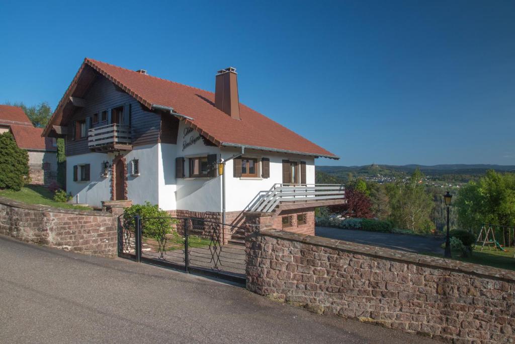 ein Haus mit Ziegelwand und Zaun in der Unterkunft Chalet Beau Regard in Hellert