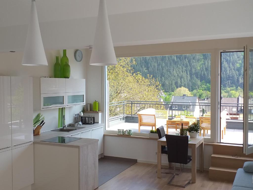 a kitchen with a large window and a table with chairs at York Cottage Heaven in Traben-Trarbach
