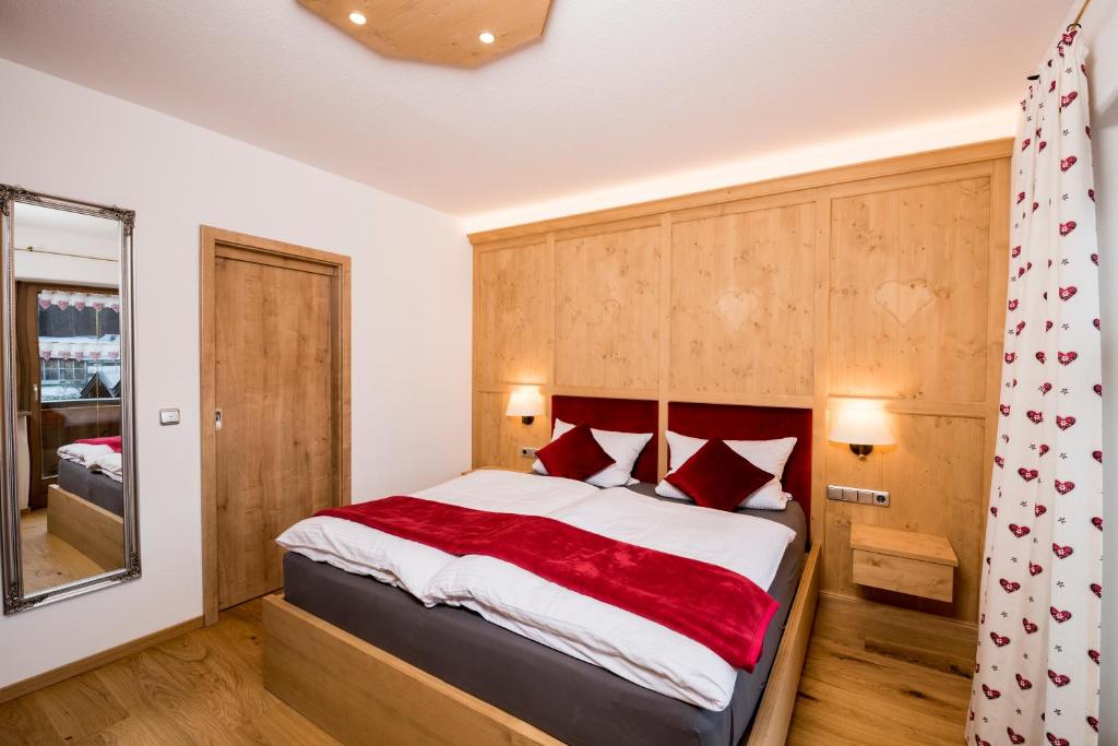 a bedroom with a large bed with red pillows at Ferienwohnung Rosenhof in Berchtesgaden