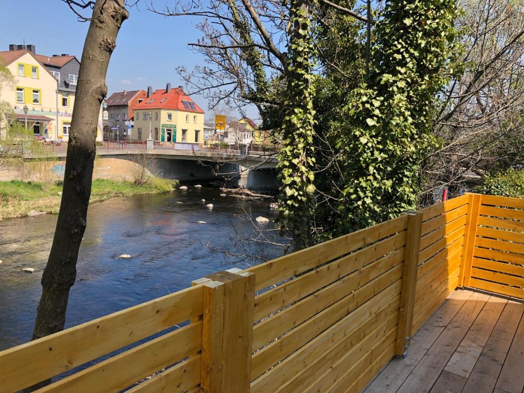 una valla de madera junto a un río con un puente en Haus an der Bode, en Thale