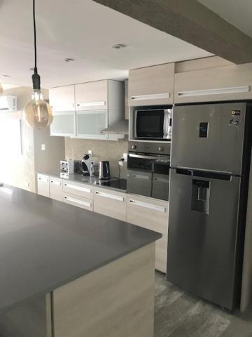 a kitchen with a stainless steel refrigerator and a microwave at Syrah Vistas Punta Ballena in Punta del Este