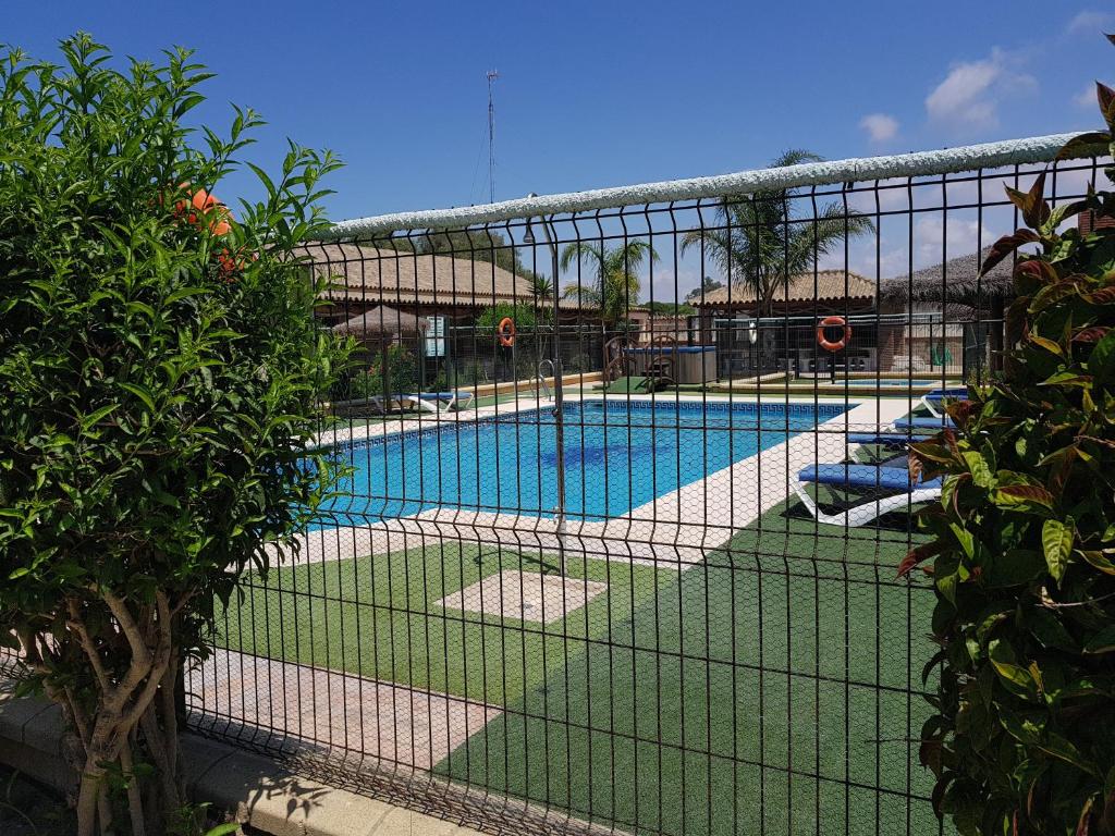 a view of a swimming pool through a fence at Residencial La Teja in Zahora