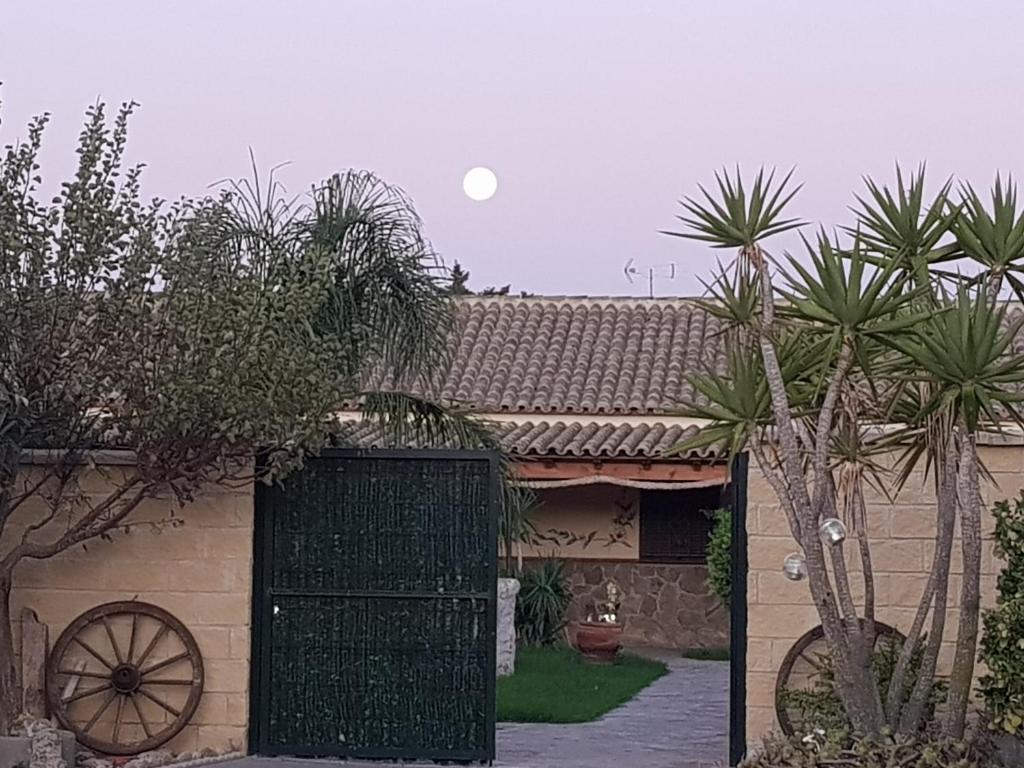 a green gate in front of a house with trees at Residencial La Teja in Zahora