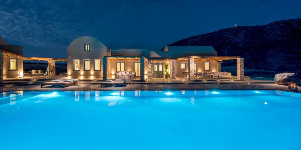 a large swimming pool in front of a house at night at Cellaria Estate Exclusive in Vlychada
