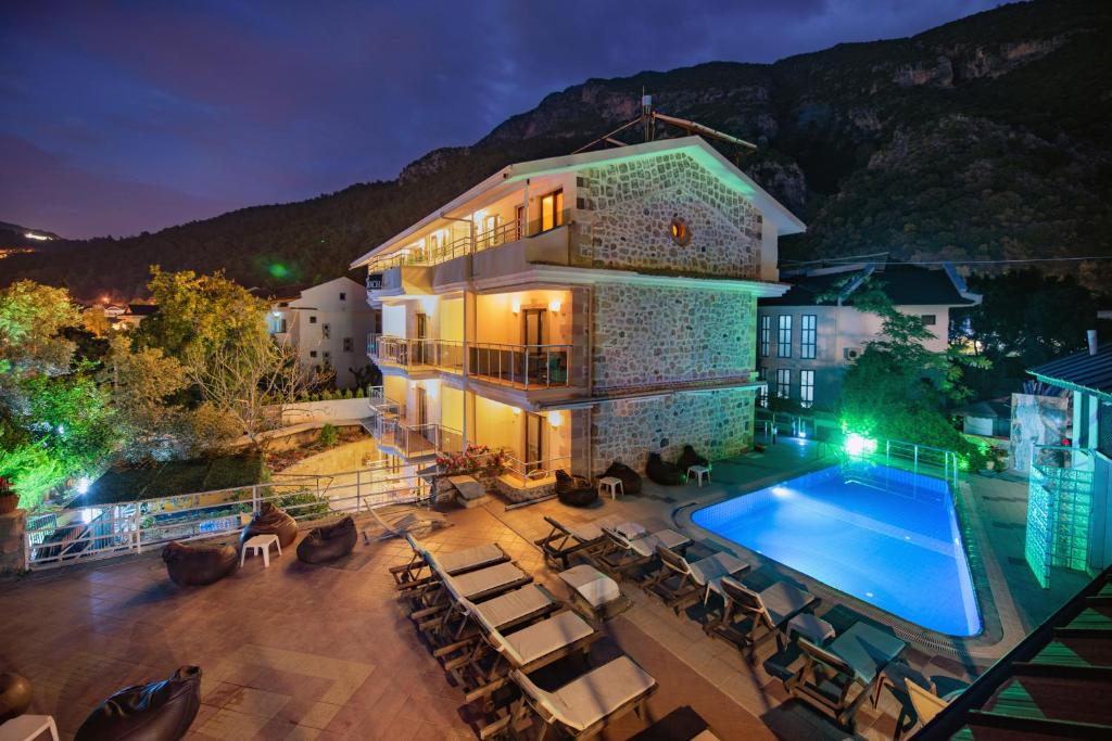 a house with a swimming pool in front of it at Seyir Beach Hotel in Oludeniz