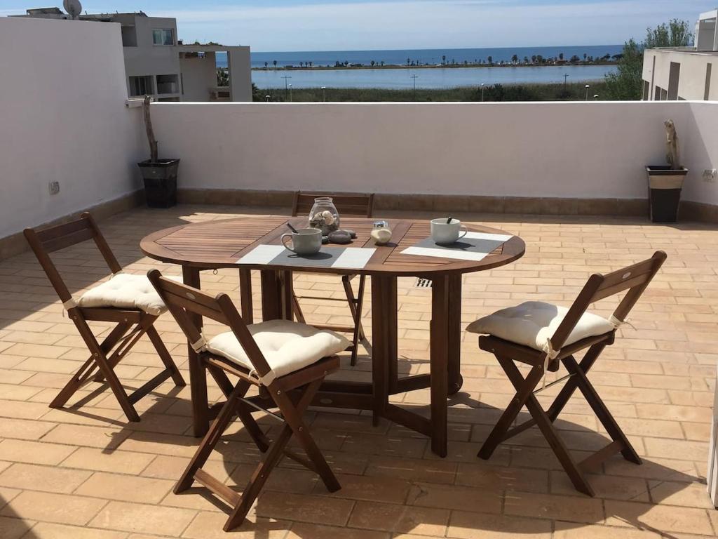 a wooden table and chairs on a patio at Attico vista mare in Su Forti