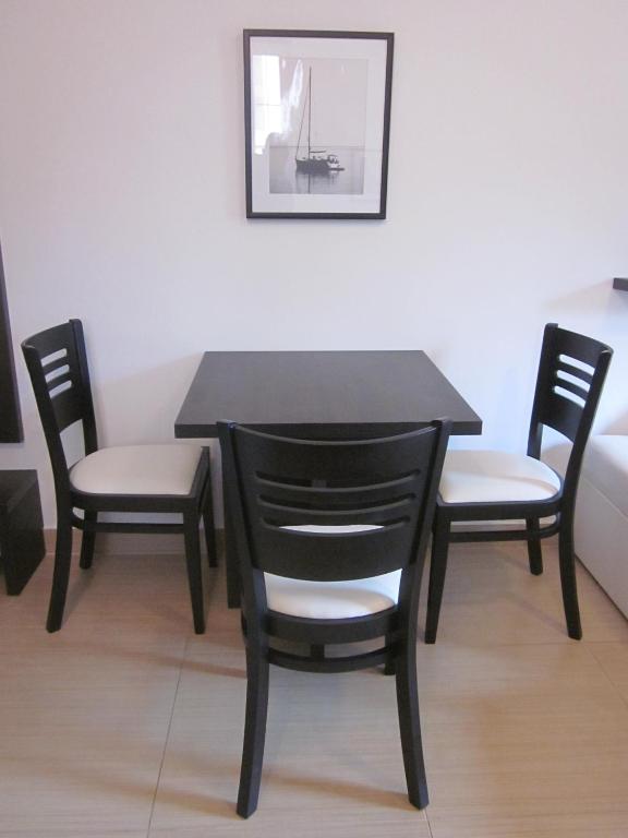 a black table with two chairs and a table and a picture at Apartments Danilo Kažanegra in Sveti Stefan