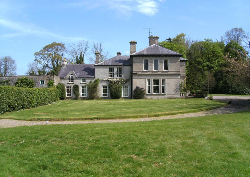 an old house with a large lawn in front of it at Gardenvale Manor House B&B in Stranocum