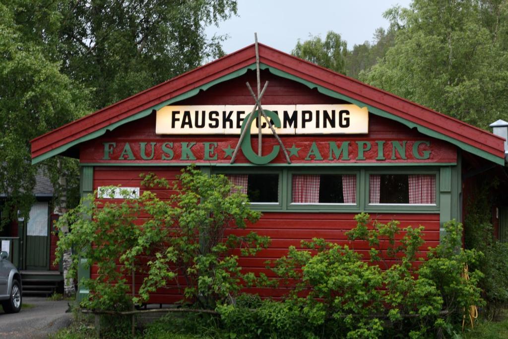 un bâtiment rouge avec un panneau en haut dans l'établissement Fauske Camping & Motel, à Fauske