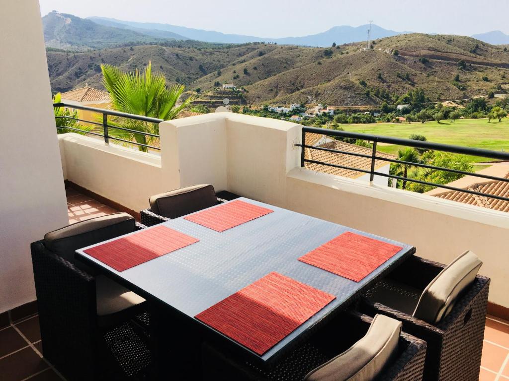 a table and chairs on a balcony with a view at Casa Mariposa in Alhaurín el Grande