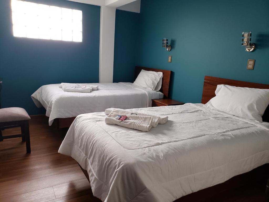 Duas camas num quarto com paredes azuis em Azul Real em Oruro