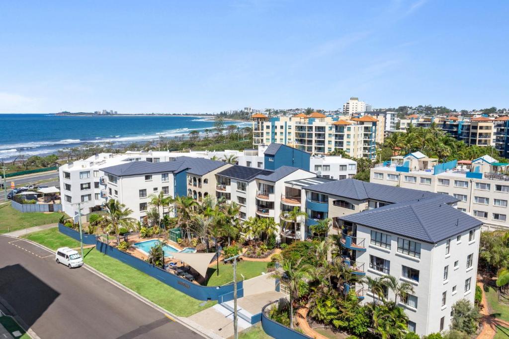 uma vista aérea de uma cidade com condomínios e do oceano em Kalua Holiday Apartments em Maroochydore