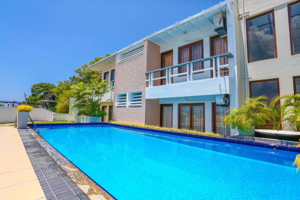 a swimming pool in front of a building at Mount Marina Villas in Galle