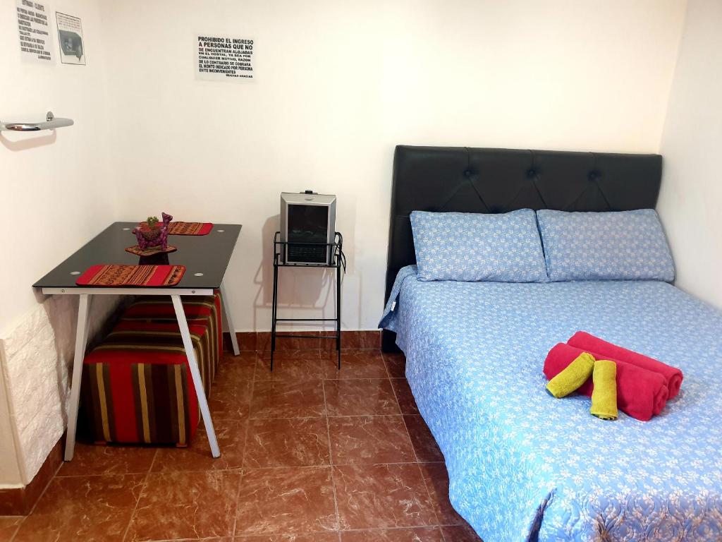 a bedroom with a bed and a table and a desk at Tilcara Hostal Niña Coya in Tilcara