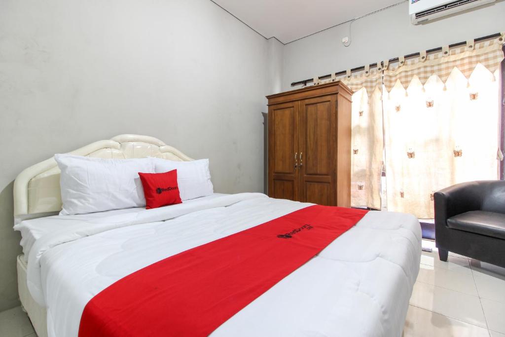 מיטה או מיטות בחדר ב-RedDoorz near Solo Balapan Station 2