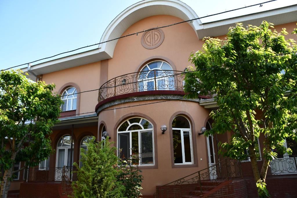 a building with a balcony on top of it at Nurziyo Guest House in Tashkent