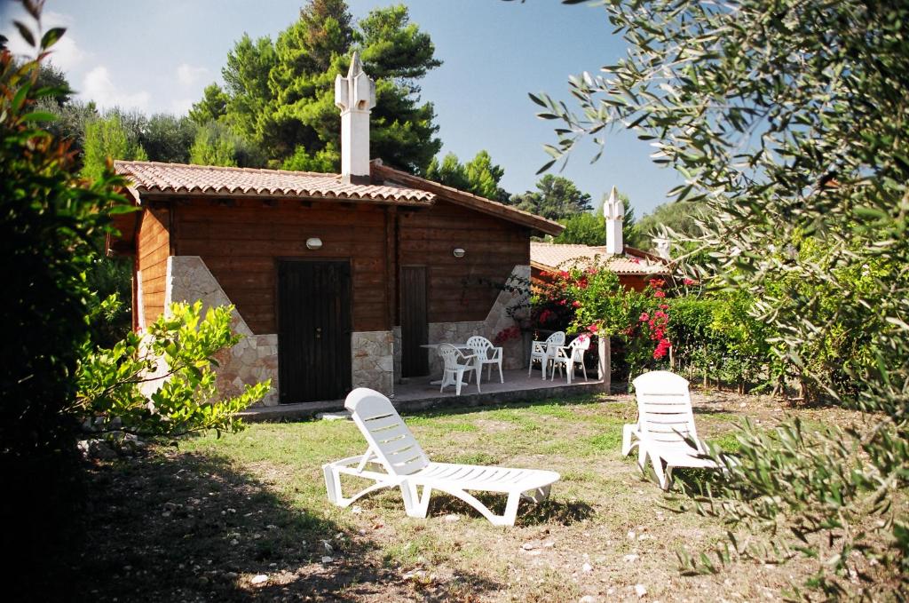 two lawn chairs and a building with a chapel at Tenuta Molino di Mare- Ecoresort in Rodi Garganico