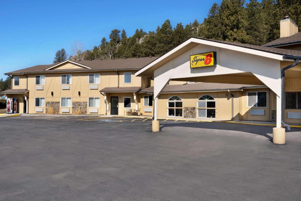 un hôtel avec un panneau dans un parking dans l'établissement Super 8 by Wyndham Custer/Crazy Horse Area, à Custer