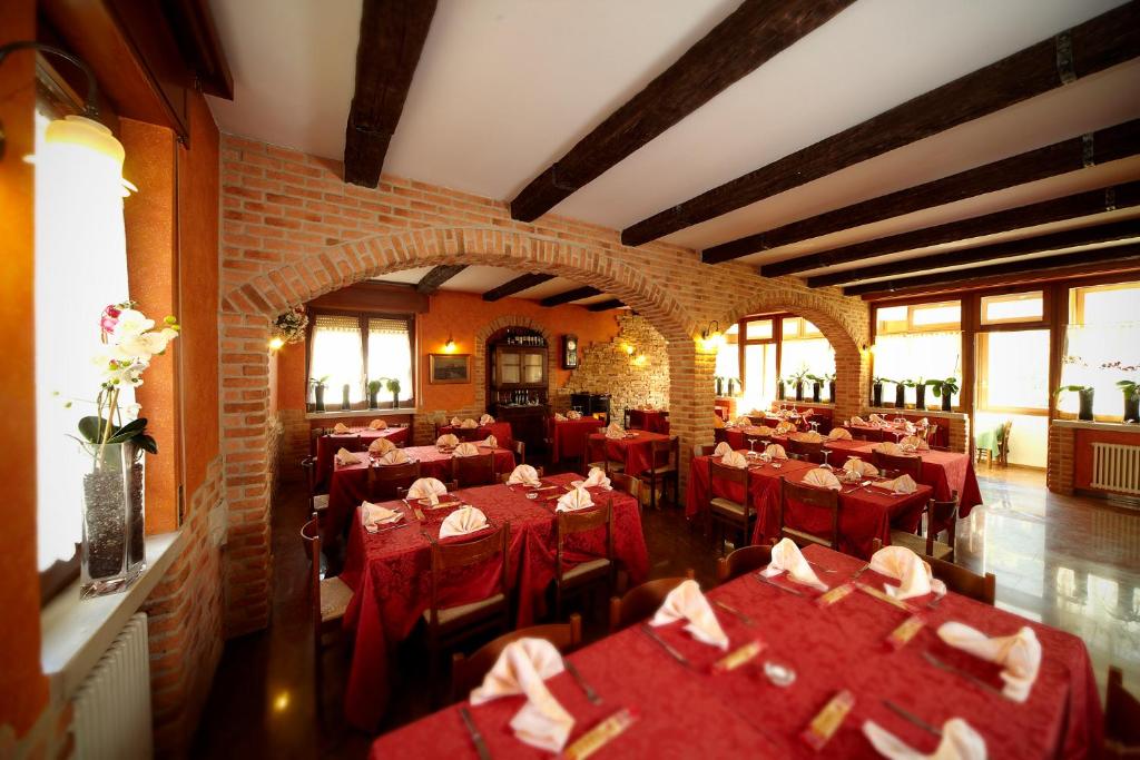 a restaurant with red tables and chairs in a room at Locanda Da Luca in Recoaro Terme
