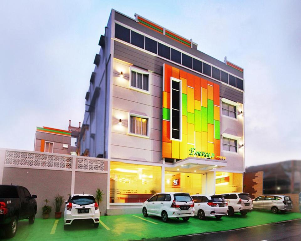 a building with cars parked in front of it at Emerald Hotel in Ternate