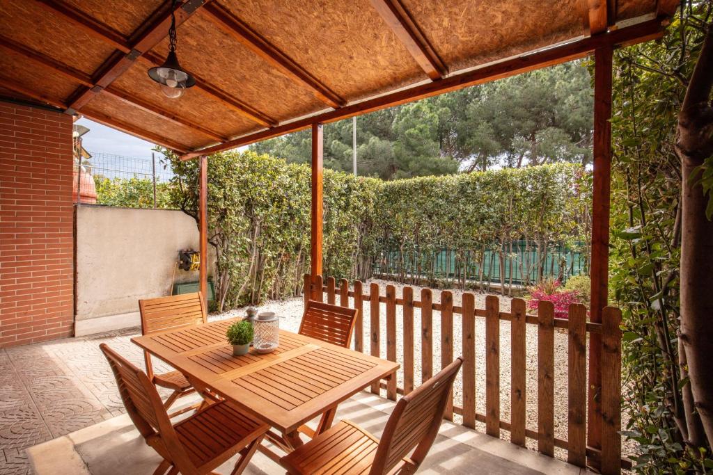 drewniany stół i krzesła na patio w obiekcie House between Rome and the sea w mieście Casal Palocco