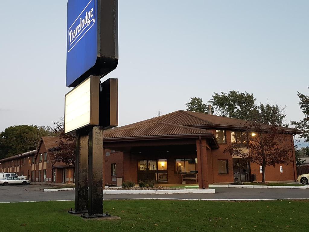 a sign on a pole in front of a building at Travelodge by Wyndham Welland in Welland