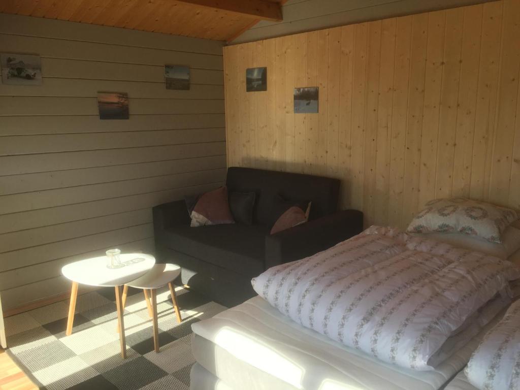 a bedroom with a bed and a couch and a table at 2/4 persoons stuga lyx in Hammarstrand