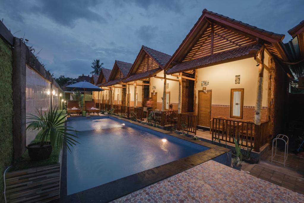 una piscina del resort di fronte a un edificio di My art Hostel and homestay a Nusa Penida