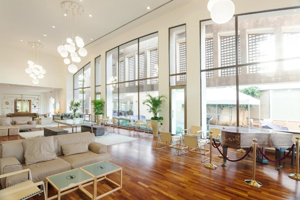 a living room with a couch and tables and windows at St Raphael Resort in Limassol