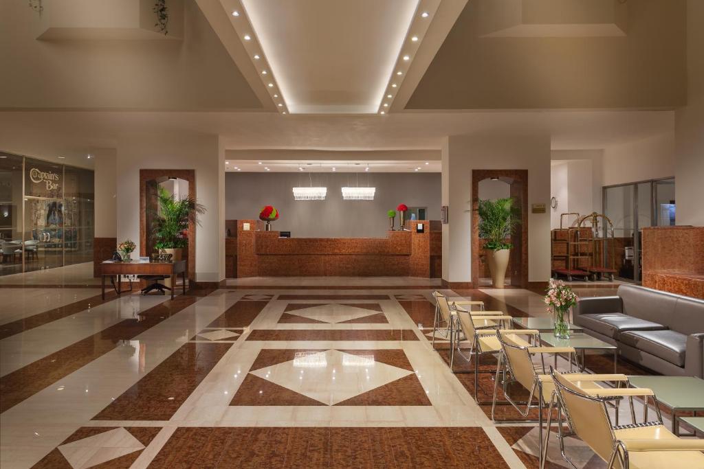 a lobby with chairs and tables in a building at St Raphael Resort in Limassol