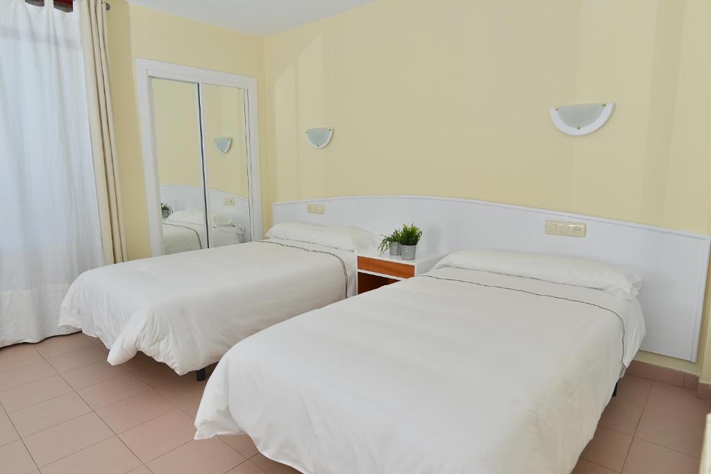A bed or beds in a room at Apartamentos Marina