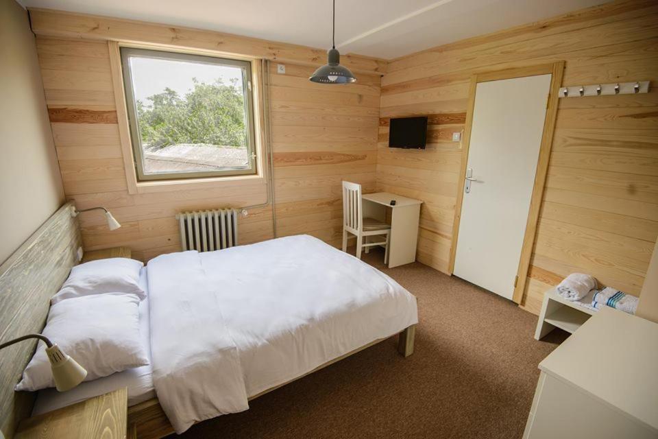 una camera da letto con un letto, una finestra e una scrivania di Gorski vrt a Novi Sad