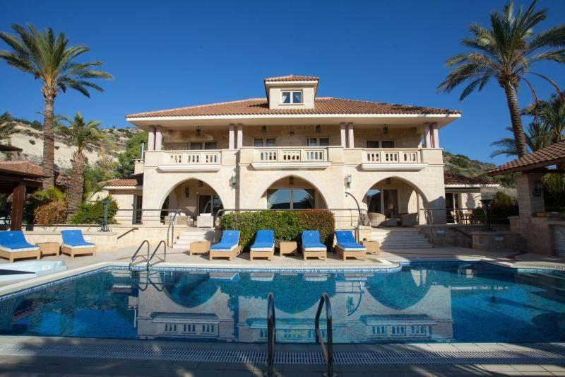 une grande maison avec une piscine en face de celle-ci dans l'établissement Casa Carmelina, à Limassol