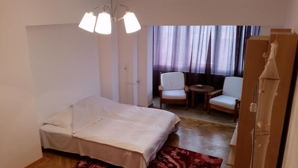 a room with a bed and two chairs and a table at Apartament Central Plaja Modern in Constanţa