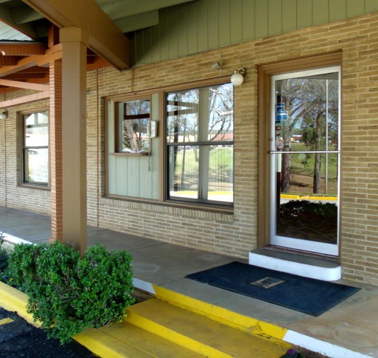 eine Eingangstür eines Backsteingebäudes mit Fenstern in der Unterkunft Woodlawn Hills Motel in Henderson