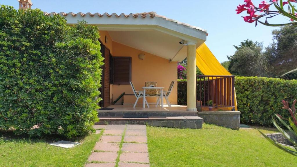 a small house with a porch with a yellow roof at LE SALINE in Calasetta