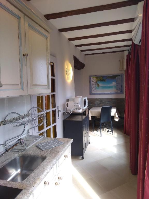 a kitchen with a sink and a table with a microwave at Villa Azur Cap d'Ail in Cap d'Ail