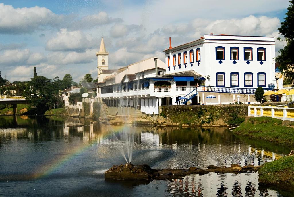 a rainbow in the water in front of a building at Nhundiaquara Hotel e Restaurante in Morretes