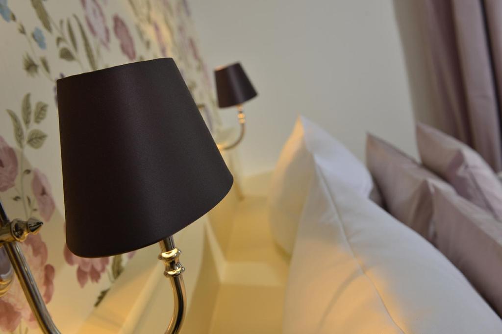 فندق دومسبيتزين في كولونيا: مصباح أسود على طاولة بجوار سرير