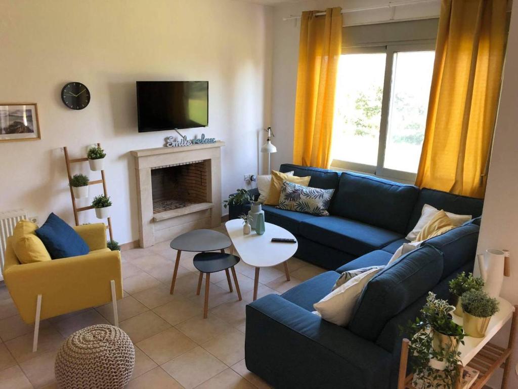 a living room with a blue couch and a fireplace at B A Seaside Villa private pool in Pefkochori