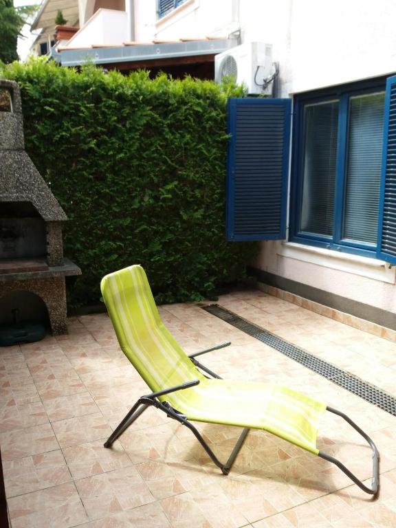 a green lawn chair sitting on a patio at APARTMAN KOREN in Malinska