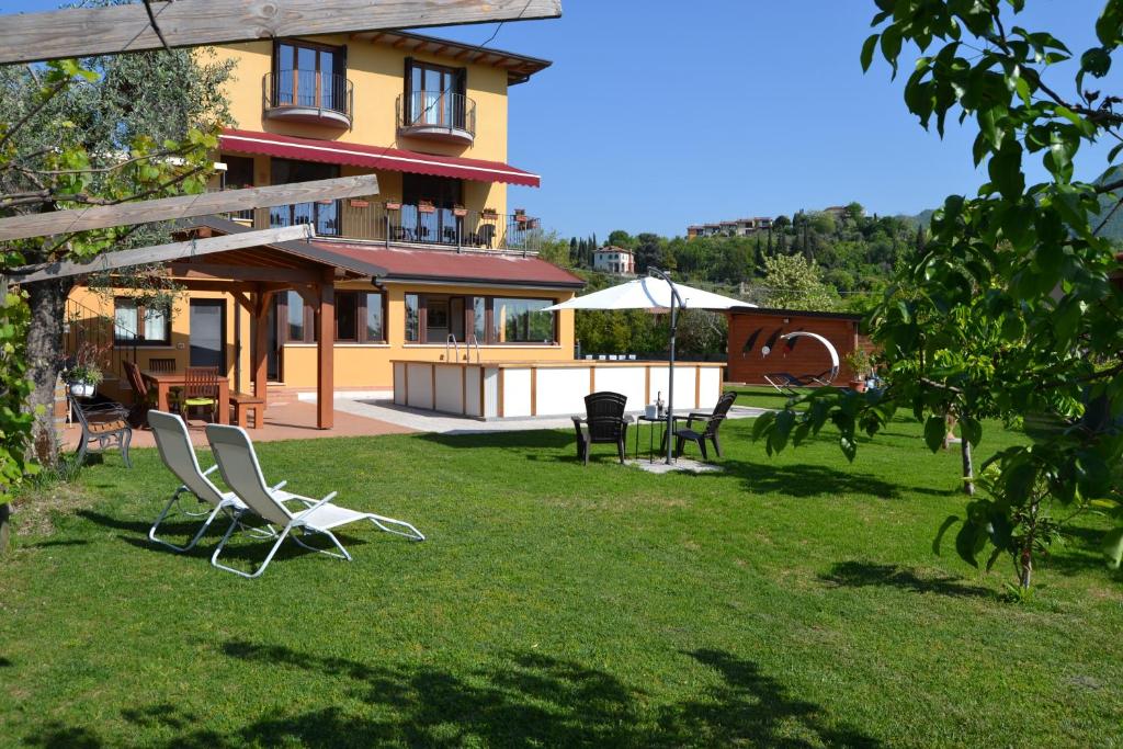 a house with lawn chairs in front of it at Villa La Veranda in Salò