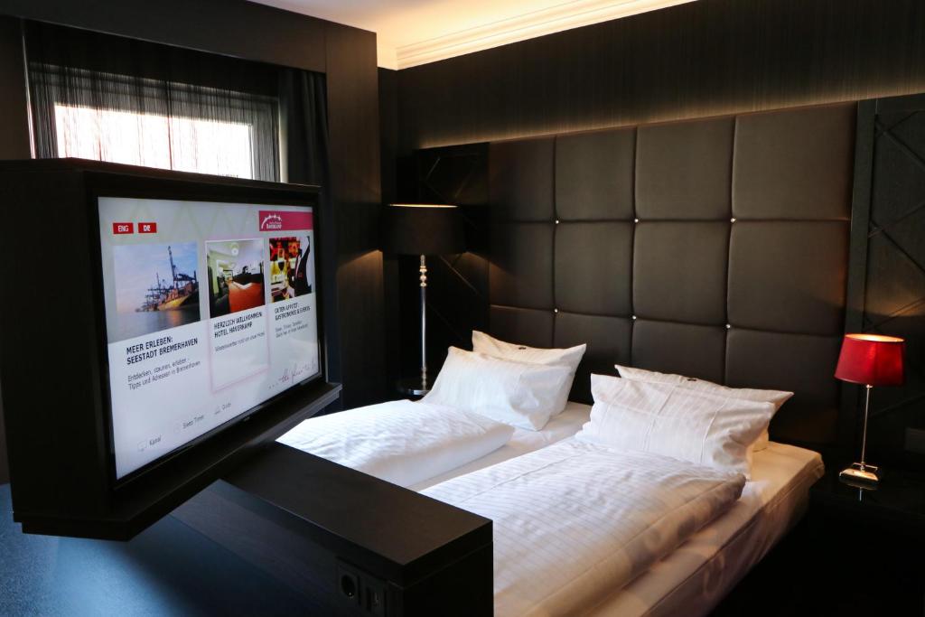 a bedroom with a bed and a flat screen tv at Hotel Haverkamp in Bremerhaven