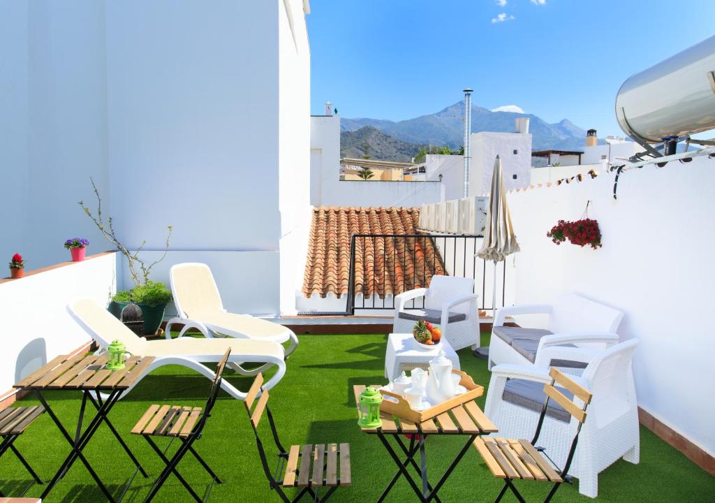 een balkon met witte stoelen en een tafel en stoelen bij Armijorooms in Nerja