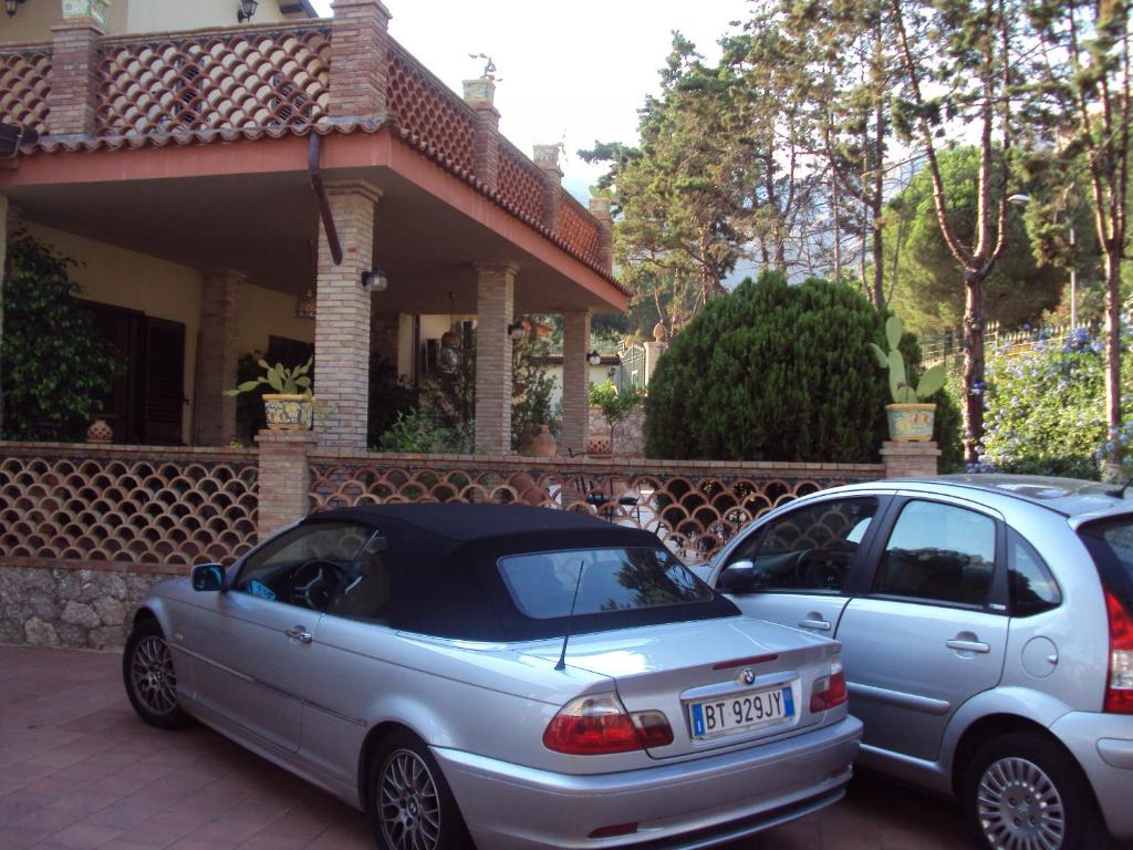two cars parked in front of a house at Villa La Spada in Taormina