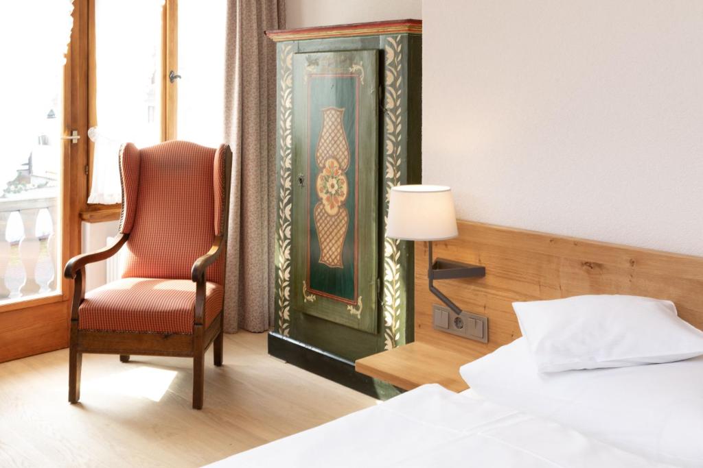 a hotel room with a chair and a window at Hotel Gasthaus Adler in Glottertal